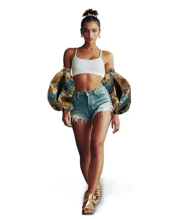 A person wearing a white crop top, denim shorts, and a patterned puffy jacket.