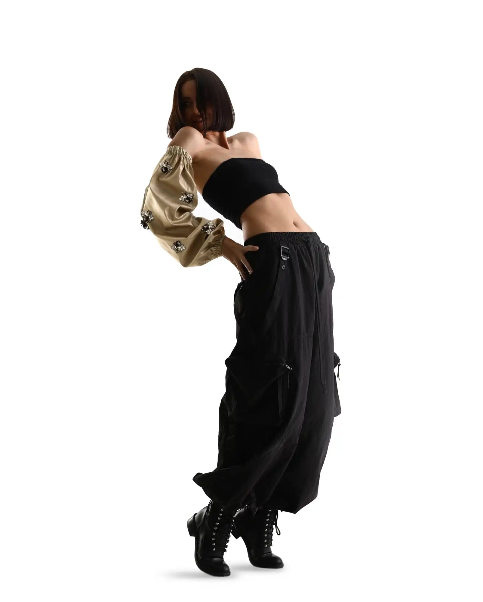 A dancer in black cargo pants and crop top striking a hip-hop dance pose.
