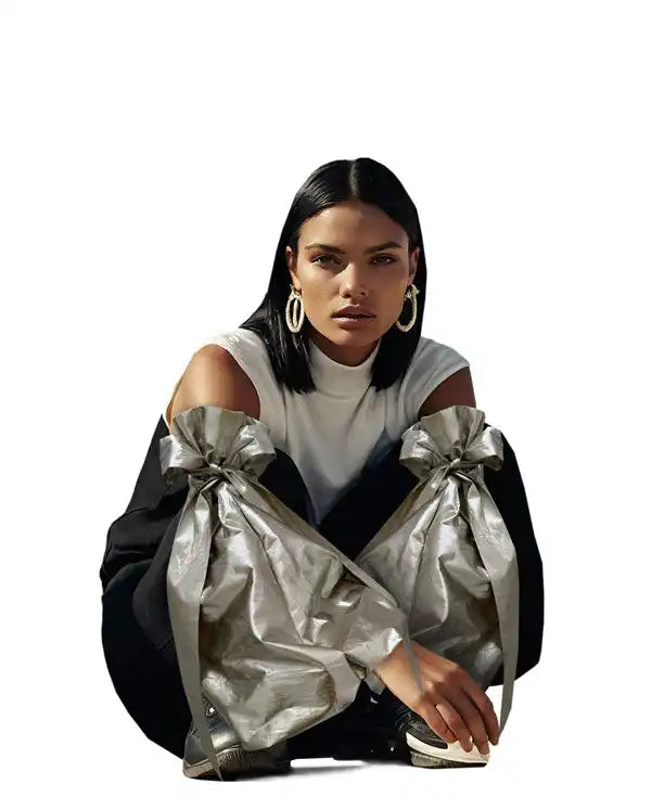A fashion model wearing a black and white outfit with dramatic bow-tied sleeves.