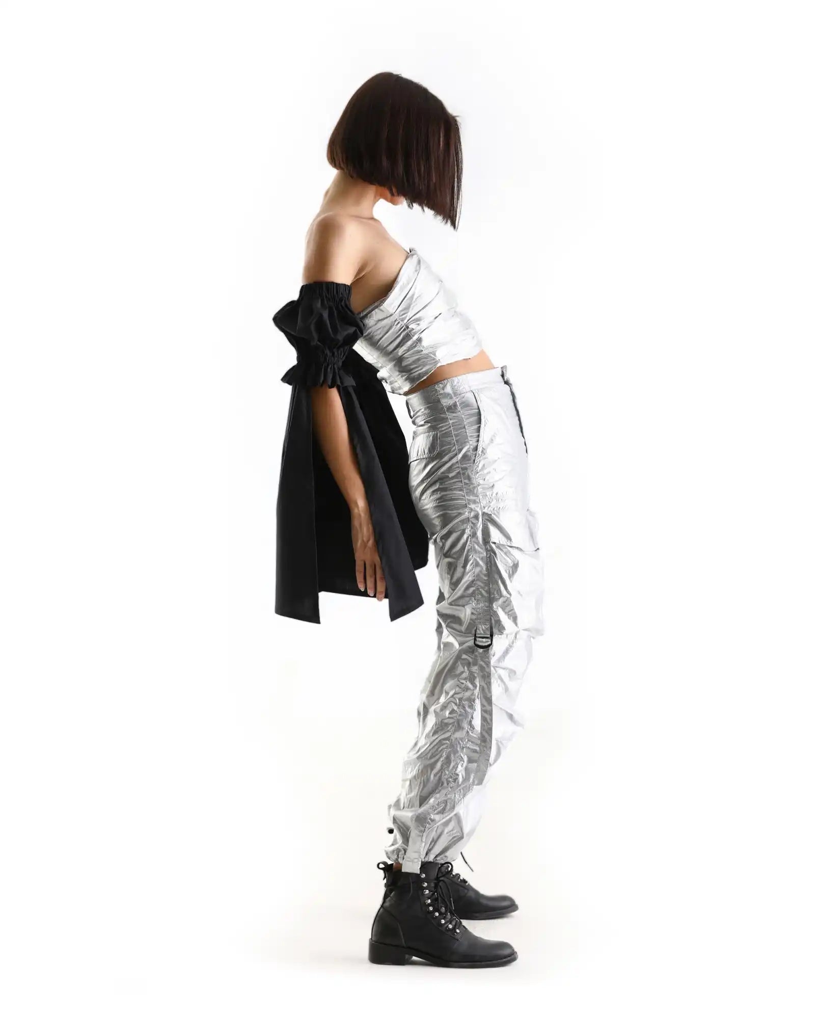 Metallic silver cargo pants paired with a white top and black combat boots.